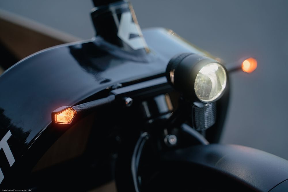 Blinker Die Front eines Lastenrades mit Scheinwerfer und Blinker im Dämmerlicht.