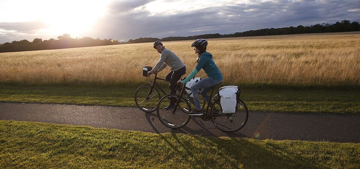 Radtour im Herbst Zwei Radfahrende auf Tour vor herbstlicher Kulisse im Gegenlicht.